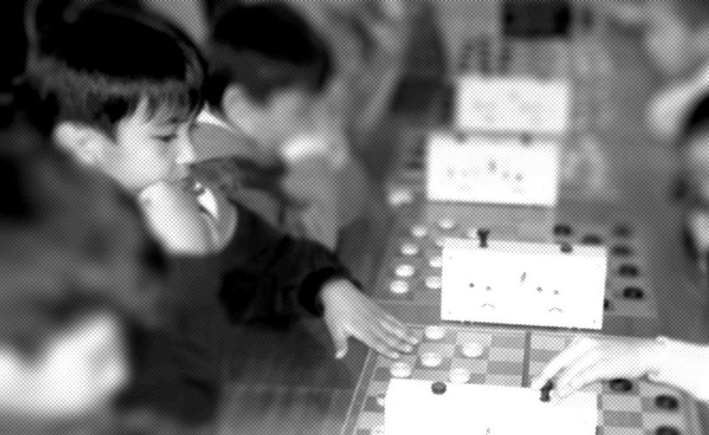 A young Yerzhan playing checkers at a tournament